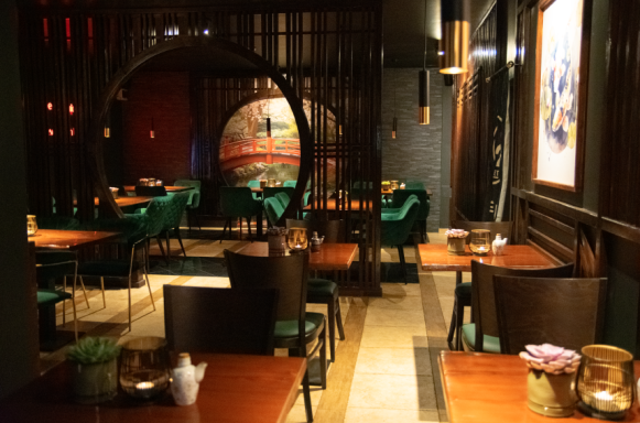 Elegantes Restaurant mit grünen Stühlen und stilvoller Beleuchtung.