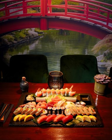 Bunt angerichteter Sushi-Teller mit verschiedenen Sorten, umgeben von einer malerischen Kulisse.