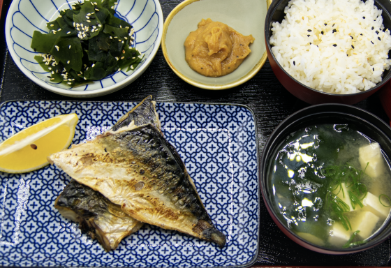 Grillfisch mit Zitrone, Beilagen aus Reis, Algen, Miso-Suppe und Senf.