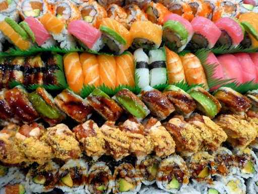 Bunte Auswahl an Sushi-Rollen mit verschiedenen Füllungen und Garnierungen.